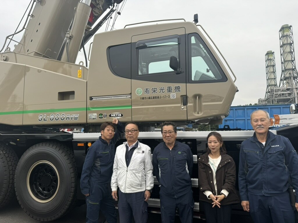 新しく納車されたラフタークレーンの前に並ぶ栄光重機の社員