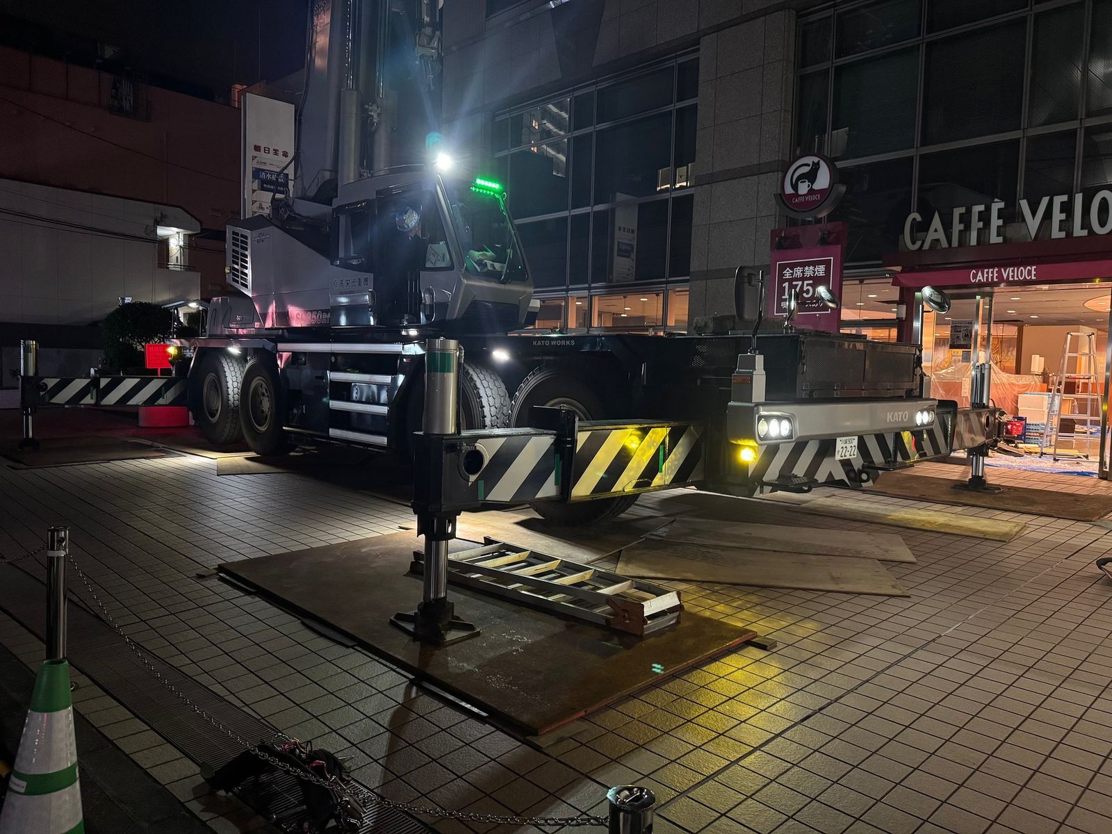 夜間の店舗前に据えたクレーン
